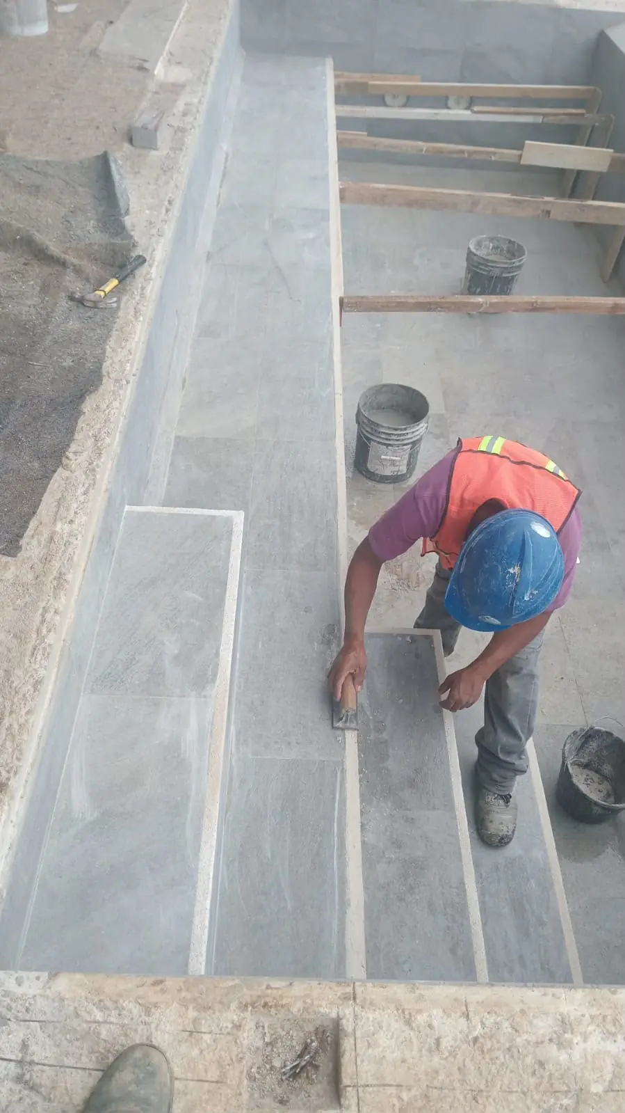 Instalación de piedra natural en las gradas de la piscina
