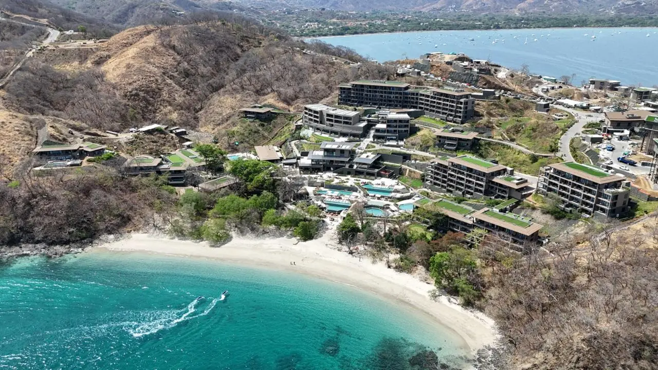 Vista aérea de un resort de lujo en la costa de Guanacaste, con villas sobre la colina y la playa